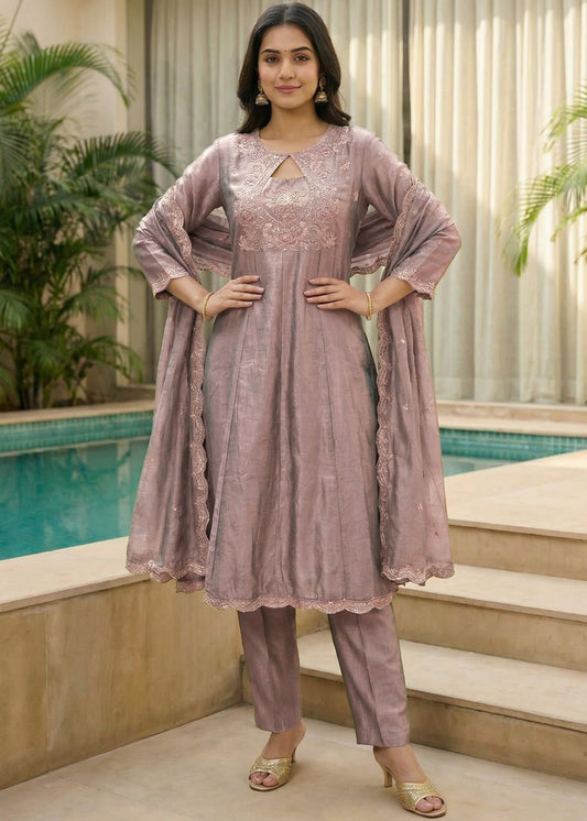Woman wearing a dusty mauve Vichitra embroidered kurta set with matching straight pants and embroidered Vichitra dupatta, featuring a round neck with keyhole detail and full sleeves, perfect for festive and ethnic occasions."