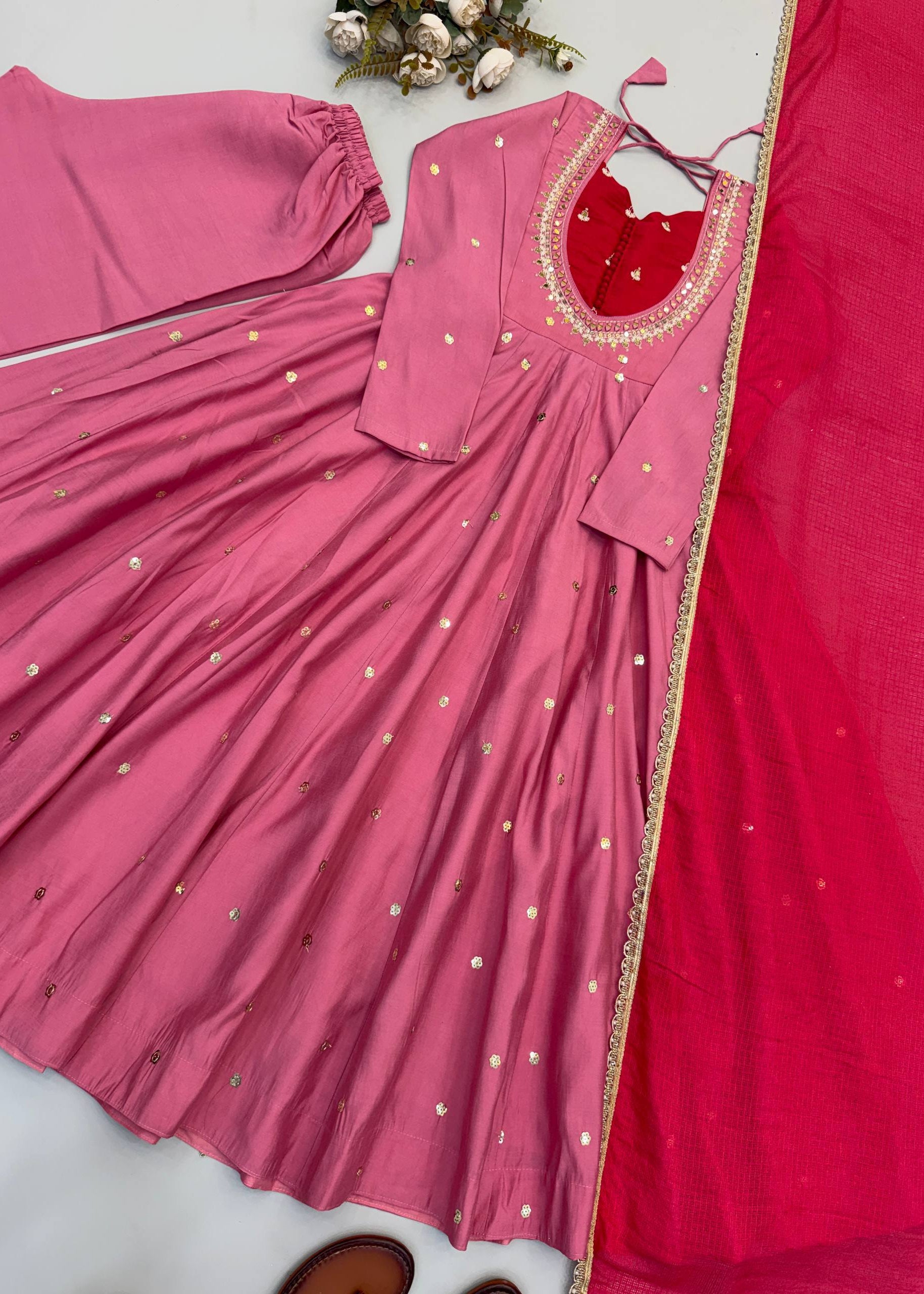 Pink traditional outfit with a blouse and saree on a white background