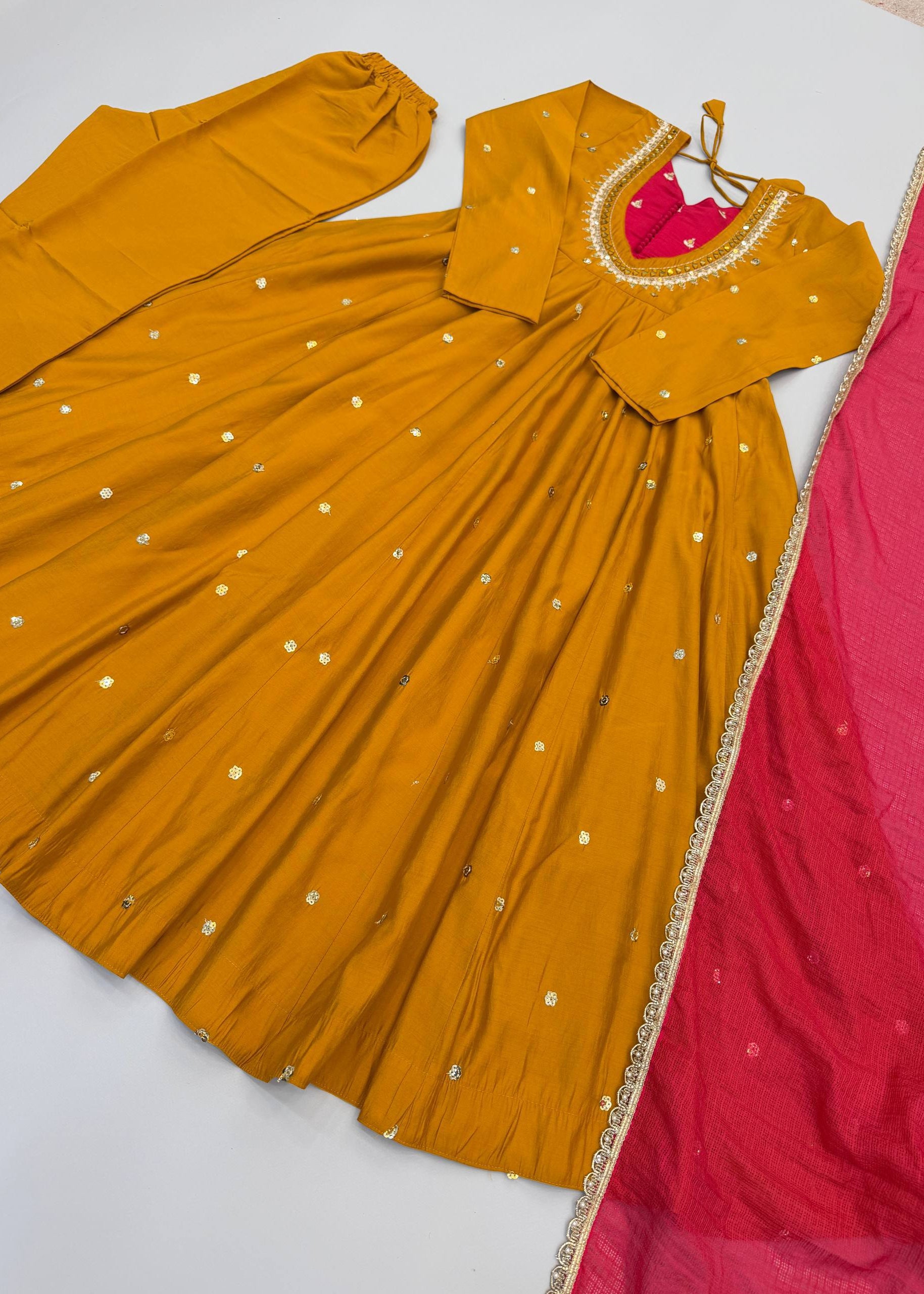 Mustard yellow and pink traditional outfit on a white background